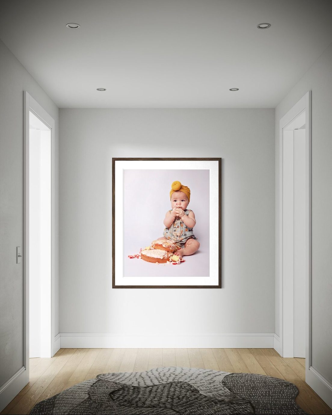 Framed portrait of a baby hanging in a bright hallway